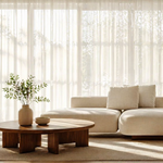 Modern living room with a beige sectional sofa, wooden coffee table, and potted plants.